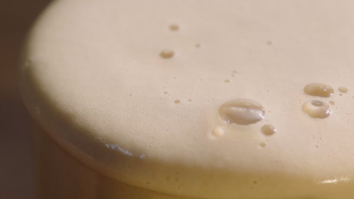 Frothy coffee spilling over a glass