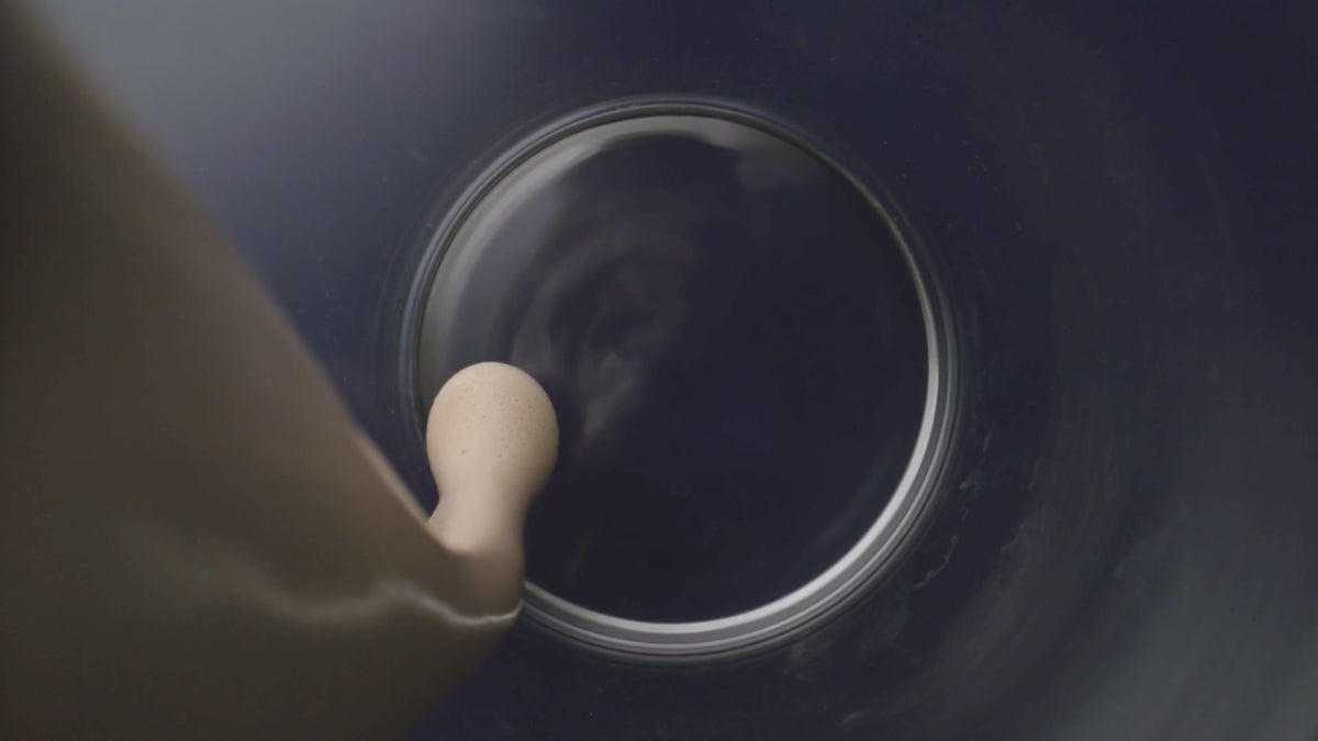 Frothed coffee pouring into a glass