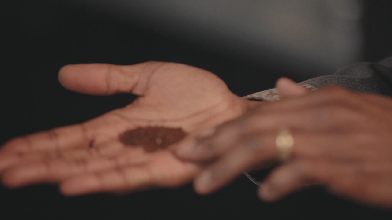 two hands handling coffee grounds