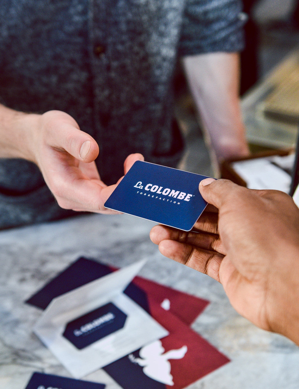 Image of someone giving a La Colombe Gift Card to someone else.